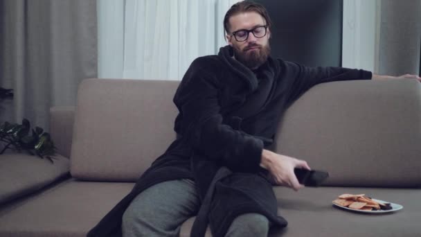 Hombre barbudo guapo relajándose en el sofá — Vídeos de Stock