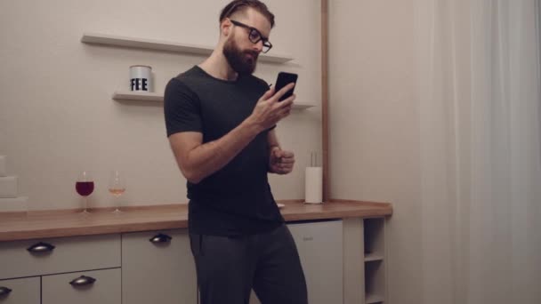 Бородатий чоловік з смартфоном танцює — стокове відео
