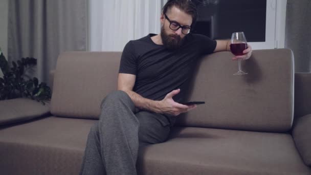 Kjekk, skjeggete mann som slapper av på sofaen – stockvideo