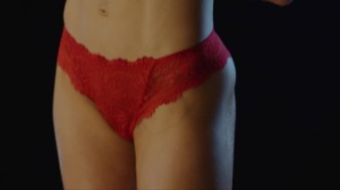 Siyah üzerine küçük bir demet çayır çiçeğiyle zinde bir kadın.