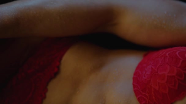 一个穿着红色内衣裤 皮肤上有露珠的健康年轻女子的躯干 — 图库视频影像