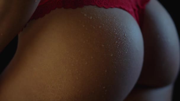 一个穿着红色内衣裤 皮肤上有露珠的健康年轻女子的臀部呈黑色 聚焦过渡 — 图库视频影像
