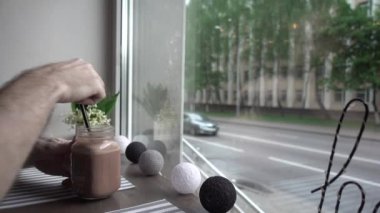 Kahve dükkanındaki masa, penceresinde bir buket bahar çiçeği, samanlı kakao...