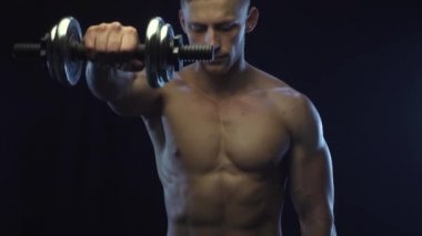 Genç formda adam omuz egzersizi yapıyor.