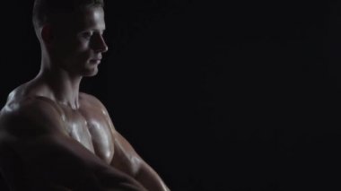 Genç formda adam omuz egzersizi yapıyor.