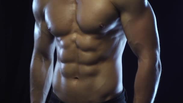 Mladý fit chlap ukazuje svaly, smyčku — Stock video