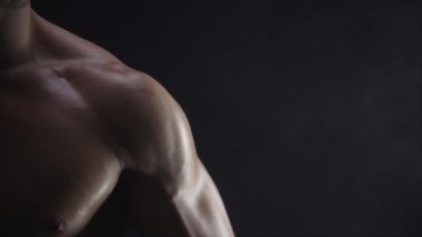 Genç, formda adam bisepsi gösteriyor, yakın çekim, yavaş çekim.