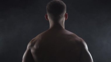 Genç adam çift pazılı, siluetli, ağır çekimde.