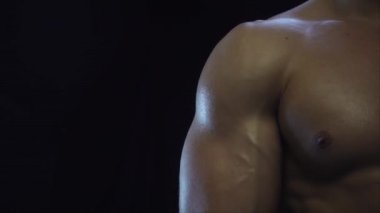 Genç, formda adam bisepsi gösteriyor, yakın çekim, yavaş çekim.