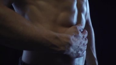 Genç fit adam poz veriyor, karın kaslarını gösteriyor, yavaş çekim.