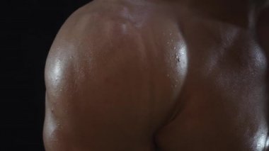 Genç formda adam poz veriyor, omuz kaslarını gösteriyor, yavaş çekim