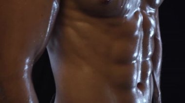 Karın kasları gösteren genç ve fit bir adam.