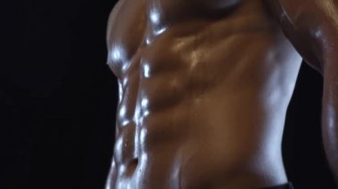 Genç fit adam poz veriyor, karın kaslarını gösteriyor, yavaş çekim, kusursuz döngü.