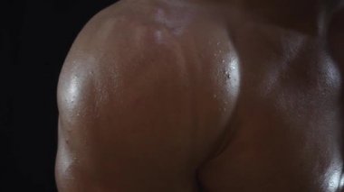 Genç formda adam poz veriyor, omuz kaslarını gösteriyor, yavaş çekim