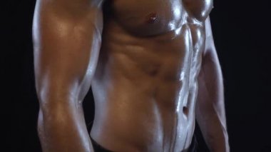 Genç fit adam poz veriyor, karın kaslarını gösteriyor, yavaş çekim.