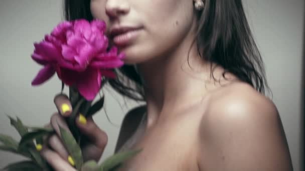 Mujer joven con flor pionera — Vídeo de stock