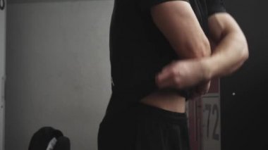 Formda bir genç adam üstünü değiştiriyor.