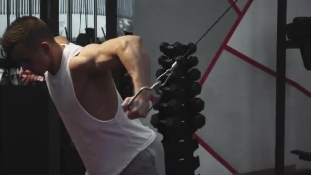 Здоровый парень делает мышцы клюва в тренажере — стоковое видео