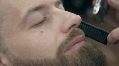 Berber dükkanındaki yakışıklı sakallı genç adam, 50 fp ile 25 fps arası yavaş çekim. Bıyık kesme