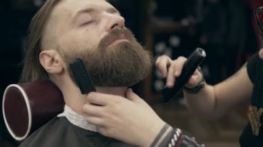 Berber dükkanındaki yakışıklı sakallı genç adam, 50 fp ile 25 fps arası yavaş çekim. Sakal kırpma