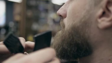 Berber dükkanındaki yakışıklı sakallı adam, 50 fp ile 25 fps arası yavaş çekim. Sakal kırpma