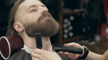 Berber dükkanındaki yakışıklı sakallı genç adam, 50 fp ile 25 fps arası yavaş çekim. Sakal kırpma