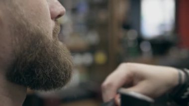 Berber dükkanındaki yakışıklı sakallı adam, 50 fp ile 25 fps arası yavaş çekim. Sakal kırpma