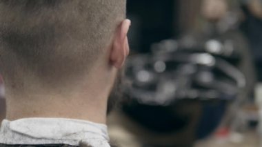 Berber dükkanındaki yakışıklı sakallı genç adam, 50 fp ile 25 fps arası yavaş çekim. Saç kesimi.