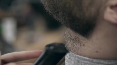 Berber dükkanındaki yakışıklı sakallı genç adam, 50 fp ile 25 fps arası yavaş çekim. Sakal kırpma