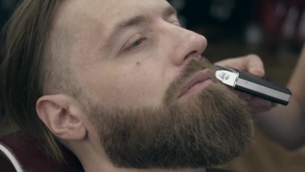 理发店里年轻英俊的大胡子男人慢动作50到25英尺每秒 胡子修整 — 图库视频影像