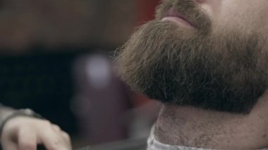 Berber dükkanındaki yakışıklı sakallı genç adam, 50 fp ile 25 fps arası yavaş çekim. Sakal kırpma