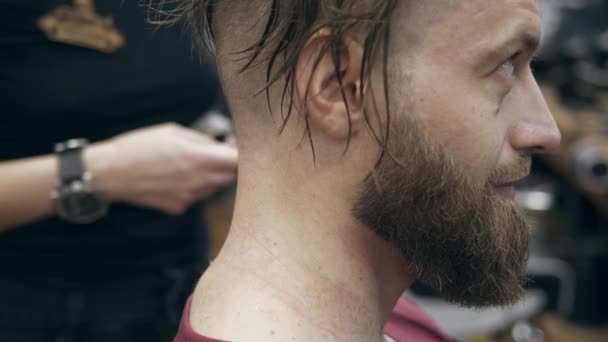理髪店でハンサムな髭の男 スローモーション50Fpsから25Fps 剃刀で髪を切る — ストック動画