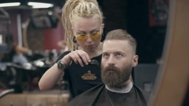 Berber dükkanındaki genç yakışıklı sakallı adam, sığ bir tarla derinliği