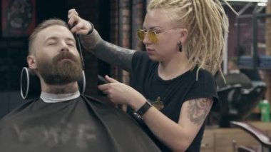 Berber dükkanındaki genç yakışıklı sakallı adam, sığ bir tarla derinliği