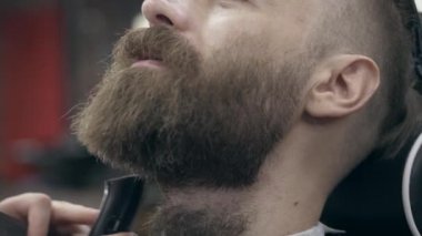 Berber dükkanındaki yakışıklı sakallı genç adam, sakal kesme, tarlanın sığ derinliği