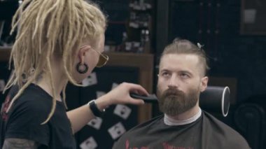 Berber dükkanındaki genç yakışıklı sakallı adam, sığ bir tarla derinliği