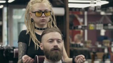 Sakallı yakışıklı bir adam. Rasta saçlı genç bir kadından, ağır çekimde. Sakal kesme tarzından bahsediyorum.