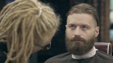 Rastalı genç bir kadın tarafından şekillendirilen yakışıklı sakallı adam, 50 fps ile 25 fps arasında yavaş çekim. Sakal kırpma