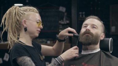 Berber dükkanındaki genç yakışıklı sakallı adam, sığ bir tarla derinliği