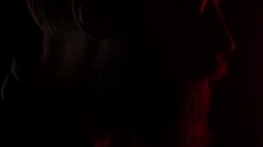 Siyahta sigara içen sakallı adam, yaklaş. Sadece çürüyen sigara gösteriliyor. Yavaş çekim