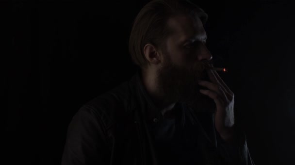 Hombre fumador en negro — Vídeos de Stock