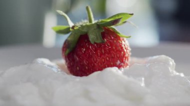 Beyaz tabakta çilek ve krema, yaklaşın. Dikey kaydırma