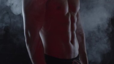 Genç, formda adam duman içinde. Yavaş çekim, dikey döndürme
