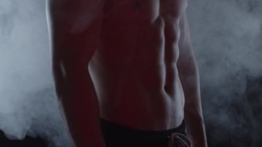 Genç, formda adam duman içinde. Yavaş çekim, dikey döndürme