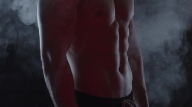 Genç, formda adam duman içinde. Yavaş çekim, dikey döndürme