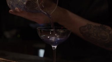 Alkol kokteyli hazırlama süreci, mavi renkli karışımı son kadehe dökme, sürgülü atış.