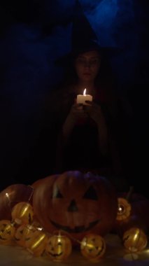 Mumla üfleyen genç cadı, yavaş çekimde. Dikey video