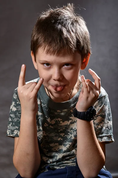 Un niño de nueve años, matones, señalando con los dedos pandillas, sacó la lengua . —  Fotos de Stock