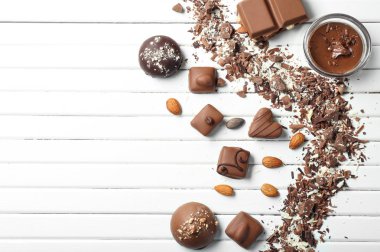Beyaz ahşap masa üzerinde farklı lezzetli çikolata şekerleme
