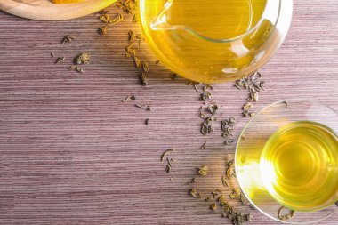 Lezzetli yeşil çay Cam Kupası ve potu ahşap arka plan, üstten görünüm